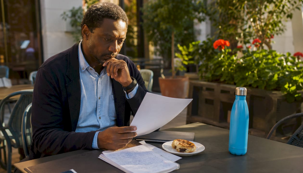 Journalist reading printed media pitch in newsroom