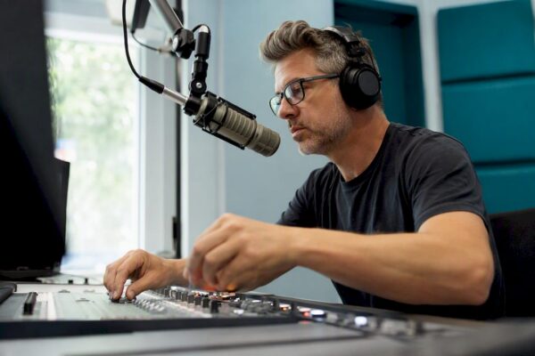 Radio host adjusting controls in studio